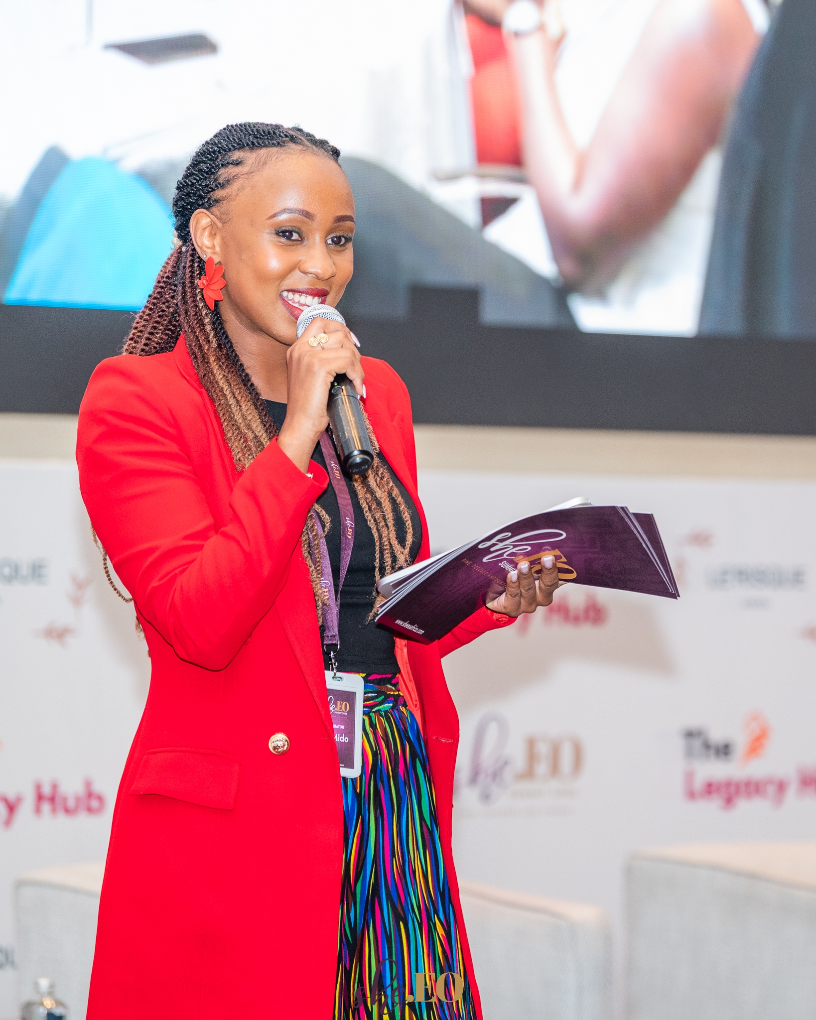 Joy Mido moderating an event on stage
